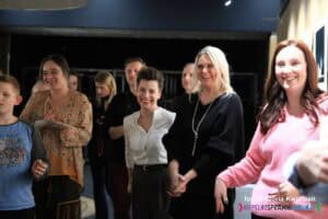 Grupa czterech młodych kobiet, stojących razem, wszystkie szeroko się uśmiechają