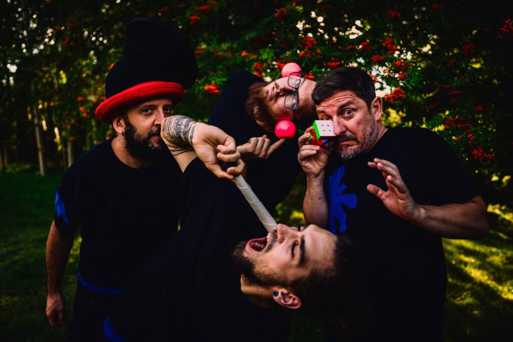 Czterej mężczyźni pozują w jarzębinowym zagajniku