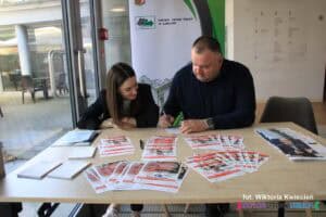 Kobieta i mężczyzna na stoisku Miejskiego Urzędu Pracy w Lublinie; na stole rozłożono materiały informacyjne