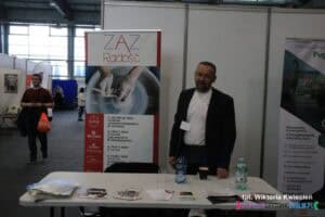 Strefa NGO na Targach Pracy: stoisko ZAZ Radość. Do zdjęcia pozuje reprezentant placówki