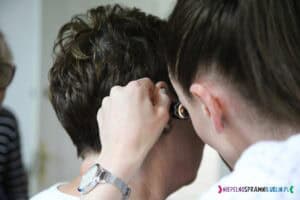 Prelegentka przeprowadza inspekcję ucha uczestniczki za pomocą otoskopu