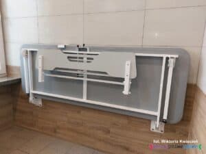 Składana leżanka zamocowana na ścianie w Komfortce