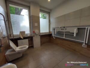 Wnętrze Komfortki. Widok na miskę ustępową i zamocowaną na przeciwko złożoną leżankę