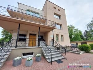 Dwupiętrowy budynek z werandą, do której prowadzą dwa symetryczne biegi po siedem schodów każdy – po jednej stronie z lewej i z prawej. W budynku mieści się kancelaria parafialna