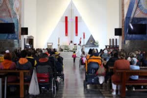 Wnętrze kościoła pw. Miłosierdzia Bożego, podczas celebracji mszy św. Widok na ołtarz i zgromadzonych wiernych