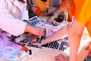 Jedna z atrakcji uroczystości: malowanie tatuaży. Na zdjęciu zbliżenie na dłonie podczas kolorowania tatuażu brokatem