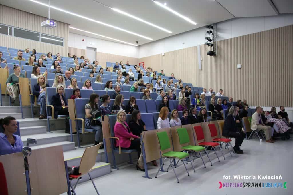 Uczestnicy konferencji zgromadzeni na widowni w sali konferencyjnej