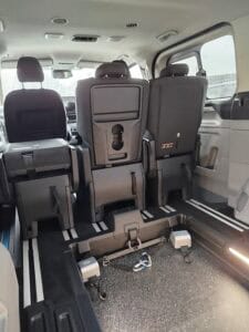 Wnętrze samochodu z miejscem na wózek inwalidzki i fotelami pasażerów w drugim rzędzie