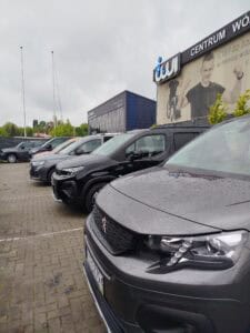 Sześć samochodów stojących w jednym szeregu na placu