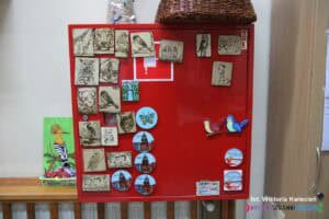 Czerwona metalowa skrzynka z ekspozycją magnesów wykonanych w pracowni pamiątkarstwa