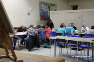 Przy stołach pracuje kilkunastoosobowa grupa uczestników warsztatów rękodzielniczych
