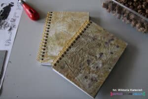 Dwa notesy zbindowane spiralnie, których okładki ozdobiono ekoprintem z roślinnymi wzorami liści