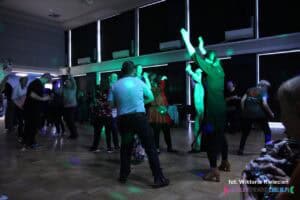 Bal integracyjny w Lubelskim Domu Technika NOT. W zaciemnionej sali grupy tańczących osób