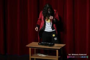 Kamil Zawada nachyla się nad instrumentem zwanym looperem