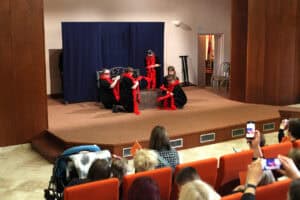 W centralnej części kadru, na scenie młodzi artyści podczas przedstawienia