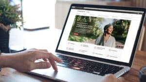 Ręka osoby przegląda portal onkologiczny na laptopie