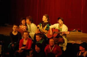 Spotkania Artystów Nieprzetartego Szlaku „Podróże w czasie”, 2011. Grupa animacyjna na scenie. Na gitarze akompaniuje Karolina Czajka