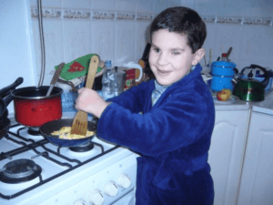 Bohater artykuły - mały Adaś w roli kucharza, przygotowuje jajecznicę w kuchni