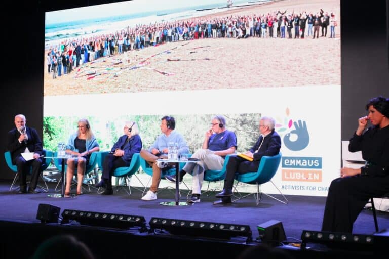 Od lewej Zbigniew Drążkowski trzymający mikrofon. Obok niego w fotelach goście, z którymi prowadzi rozmowę. Po prawej stronie tłumaczka języka migowego