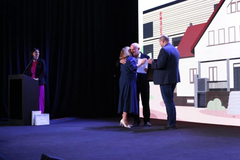 W centrum kadru Zbigniew Drążkowski odbierający nagrodę. Po lewej, przy mównicy, prowadząca spotkanie Iwona Kędziera