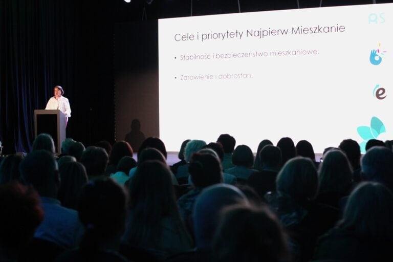 Na fotografii od lewej, Anna Gazda podczas prelekcji. Z prawej, ekran z wyświetlonym tematem wystąpienia „Najpierw Mieszkanie”