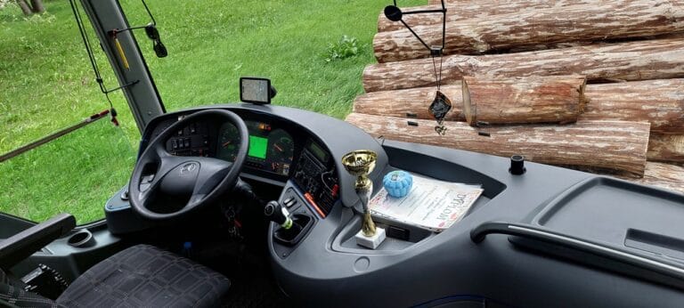 Widok na stanowisko kierowcy w autokarze – z kierownicą, zegarami i przyciskami na desce rozdzielczej. W centralnym punkcie umieszczono otrzymany podczas festiwalu puchar i dyplom
