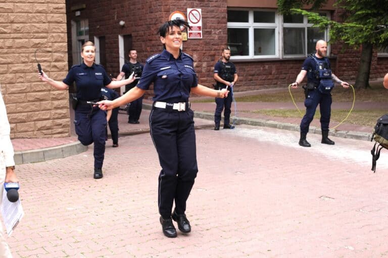 Na pierwszym planie policjantka przygotowuje się do podskoku. Z nią koleżanka i koledzy. Wszyscy ze skakankami