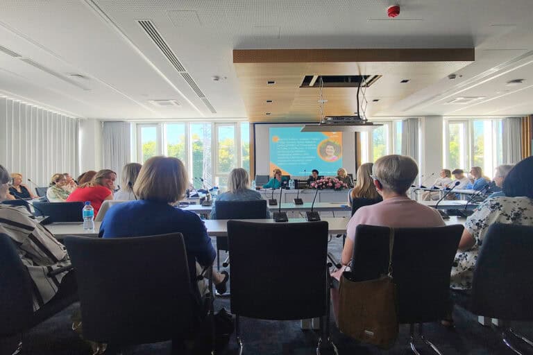 Na pierwszym planie zgromadzeni słuchacze. W tle, w centralnej części kadru ekran ze zdjęciem prof. Barbaro