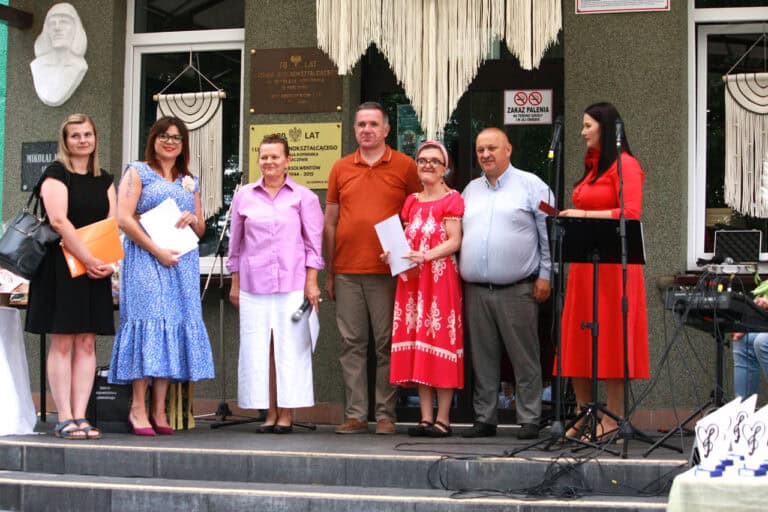 Do wspólnej fotografii pozują członkowie jury, prowadząca wydarzenie i zwyciężczyni, która trzyma w rękach podziękowanie