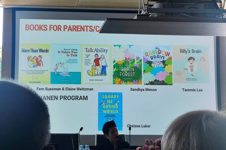 Zdjęcie ekranu multimedialnego wyświetlającego okładki książek dla rodziców dzieci z autyzmem