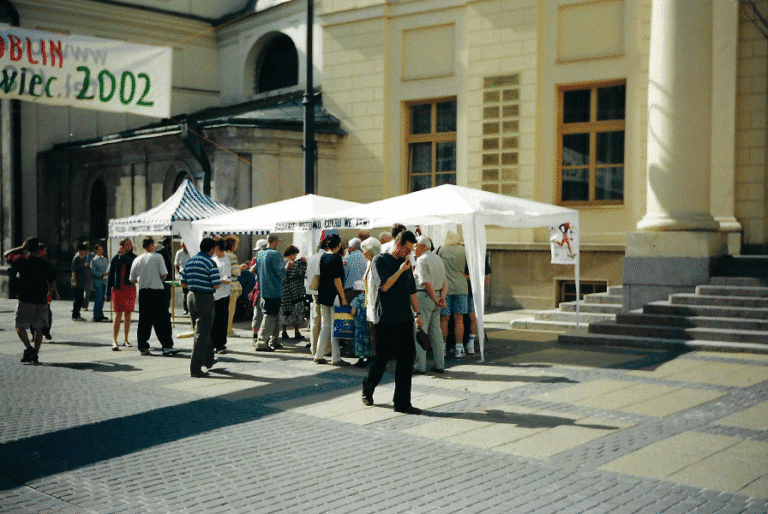 2002, Plac Króla Władysława Łokietka 1 przed budynkiem Nowego Ratusza ustawiono stoiska namiotowe, przed którymi gromadzą się mieszkańcy Lublina