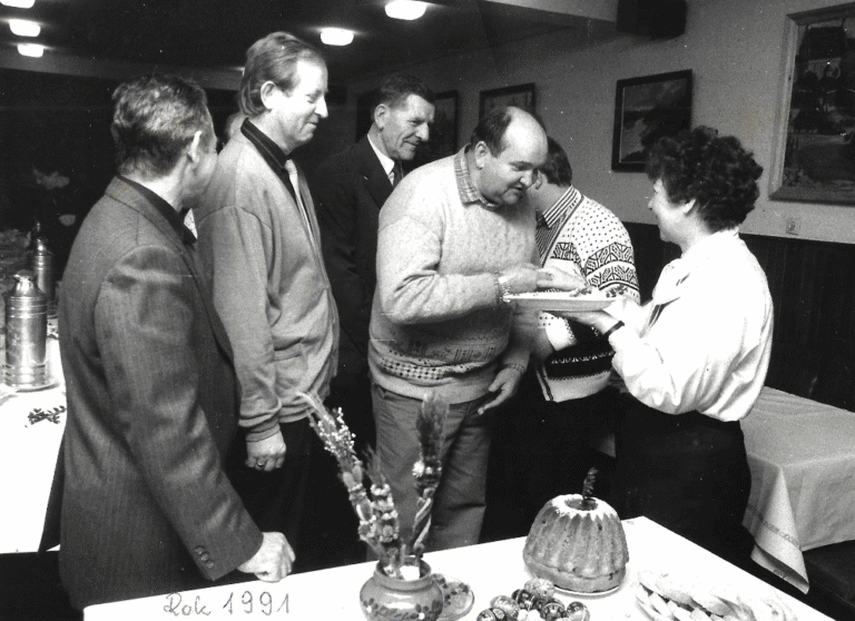 Wielkanoc 1991; mężczyzna pochyla się ściskając rękę kobiety, towarzyszy mu czterech mężczyzn