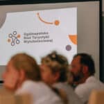 Ekran multimedialny z wyświetlonym slajdem z logo Ogólnopolskiej Sieci Turystyki Wytchnieniowej