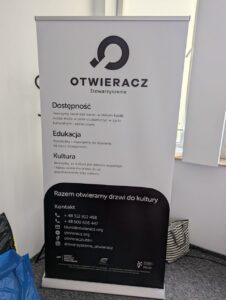 Roll up Stowarzyszenia „Otwieracz” z logo i danymi teleadresowymi, prezentujący założenia działalności organizacji: dostępność, edukacja, kultura.