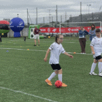 Dziewczynka w białej koszulce przy piłce, w tle Arena Lublin