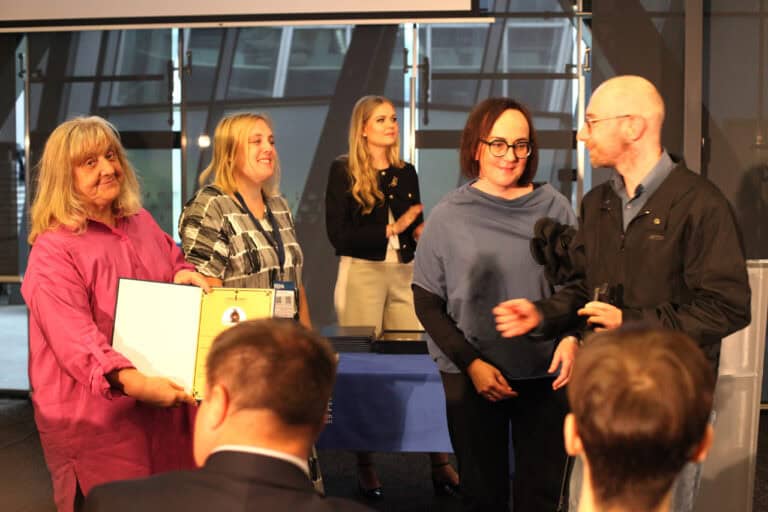 Grupa pięciu osób na scenie po ceremonii. Kobieta z lewej, w różowej koszuli, trzyma dyplom (Alicja Jankiewicz - Prezes Honorowa LFOON-SW). Obok niej stoją dwie uśmiechnięte kobiety (jedną z nich jest Anna Bieganowska-Skóra - Prezes LFOON-SW). Po prawej stoi bokiem mężczyzna w okularach (Łukasz Lewicki - Wiceprezes LFOON-SW). W tle widoczne są duże okna