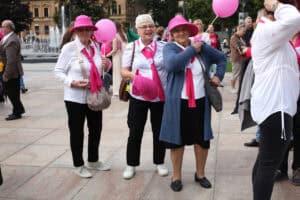 Plac Litewski w Lublinie. Trzy kobiety wyróżniają się na tle zgromadzonych ludzi. Mają na sobie różowe elementy garderoby. Jedna z nich trzyma różowy balon