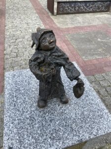 Mały posąg krasnala z brązu o imieniu „Batiaryga” na Rynku Solnym w Zamościu