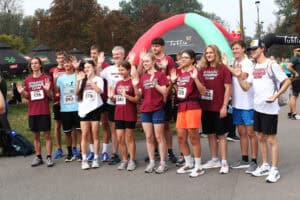 Do fotografii pozuje grupa zawodników w koszulkach z napisem: "Staszic Running Team"