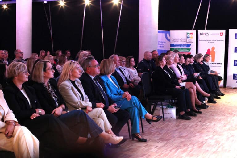 Wnętrze sali konferencyjnej, widok zgromadzonych gości, którzy siedzą na ustawionych w rzędach krzesłach. W tle stojące banery ROPS, Regionalnego Punktu Diagnozy i Terapii i Polskiego Radia Lublin