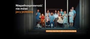 Grupa osób, w tym osoby z widocznymi niepełnosprawnościami, stoi razem przy dobrze oświetlonym oknie wystawowym. Tekst na obrazie brzmi: Niepełnosprawność nie mówi jacy jesteśmy. Poznaj nas na fundacjaavalon.pl.