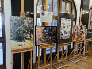 W korytarzu biblioteki na sztalugach wyeksponowano prace plastyczne, obrazy.