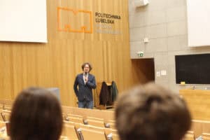 Dr hab. Andrzej Kapusta przemawia do słuchaczy w auli Politechniki Lubelskiej; w tle logo Wydziału Mechanicznego.