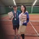 Na krytym korcie tenisowym stoją od lewej Sławomir Tolak i Justyna Szafranek. Na szyjach mają medale, w rękach trzymają dyplomy za 1. i 2. miejsce w turnieju blind tenisa.