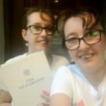 Siostry Wróbel ubrane w białe tshirty. Marta trzyma teczkę z napisem Akt notarialny – fotografia z dnia rejestracji Fundacji Moc Słabości