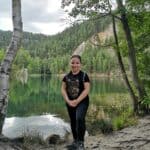 Anna Grzesik-Kontek pozuje nad brzegiem jeziora otoczonego zielonymi drzewami w Skalnym Mieście Adršpach w Czechach