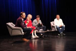 Czworo uczestników panelu siedzi w fotelach na scenie, od lewej: Józef Szopiński, Weronika Stachyra, Jakub Basa, Artur Pałyga