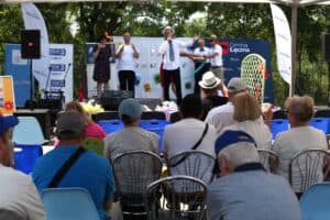 Na scenie występuje mężczyzna w białym stroju, z krawatem, obok niego inne osoby grają na instrumentach. W tle baner z napisem „Festiwal Moich Pasji”; widok z widowni