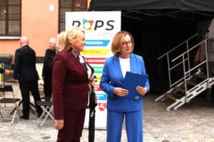 Dwie kobiety stoją przed banerem „ROPS Lublin”. Kobiety uśmiechają się. Pierwsza z prawej stoi Małgorzata Romanko.