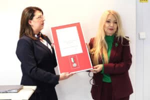 Anna Augustyniak i Justyna Szafranek wspólnie prezentują dyplom i medal w czerwonej ramie.